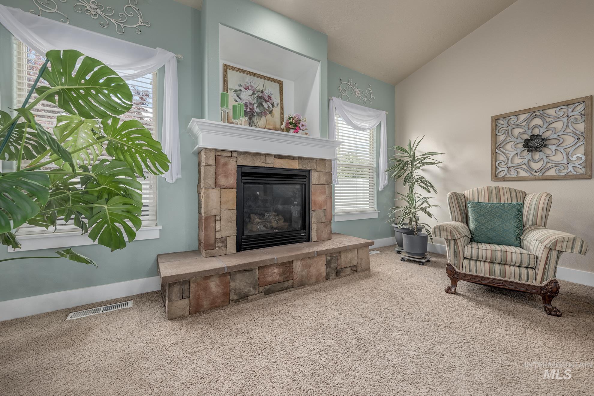 420 West Indianhead Road Weiser, ID 83672 - Photo 9 of 40 Stone-clad fireplace with a raised hearth and white mantel, featuring a black firebox insert