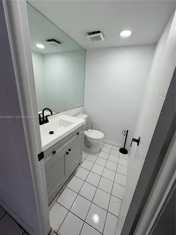 a bathroom with a sink a toilet a mirror and shower