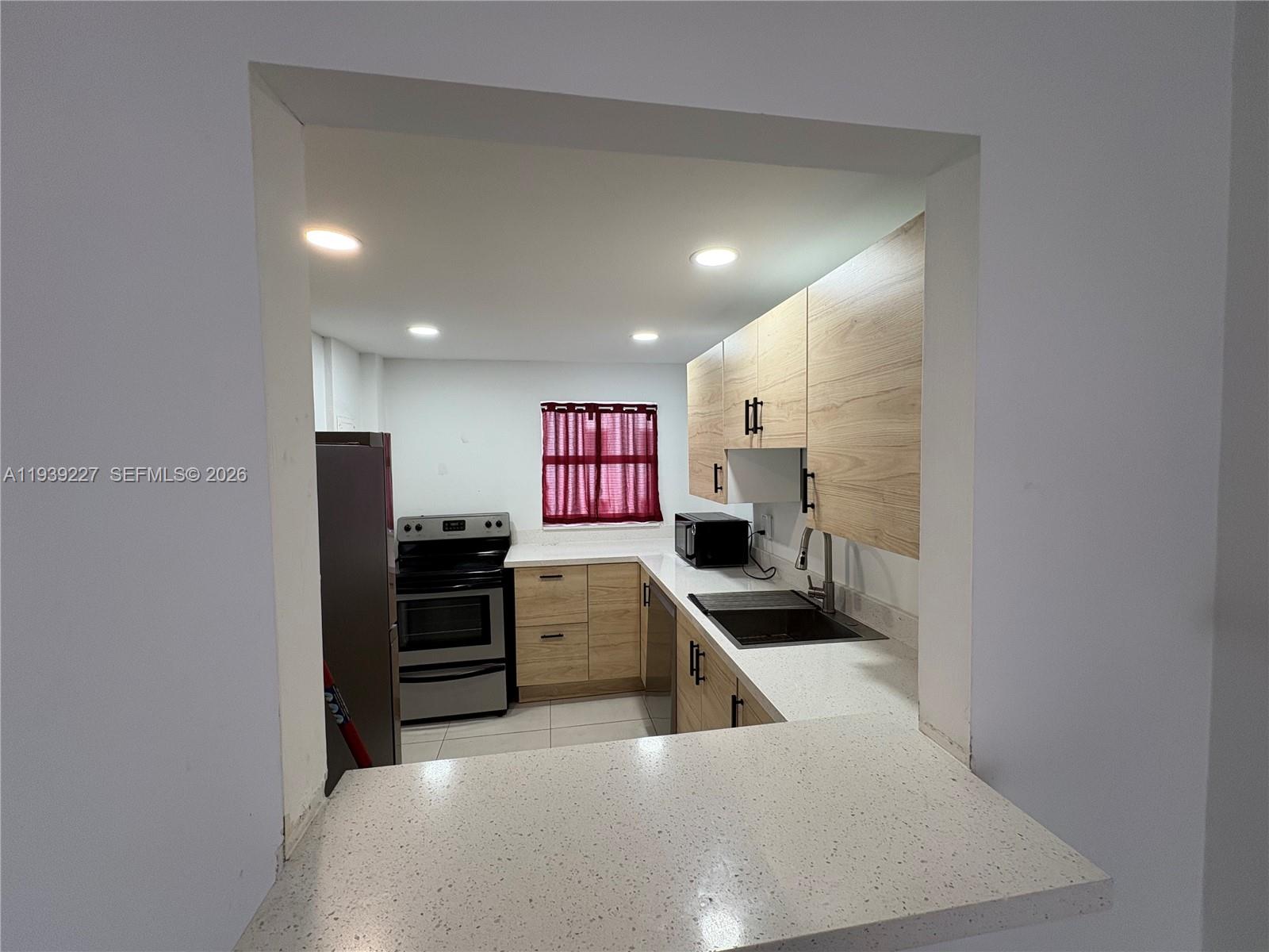 1331 Lincoln Road, Unit 402 Miami Beach, FL 33139 - Photo 7 of 20 a kitchen with stainless steel appliances granite countertop a refrigerator and a sink