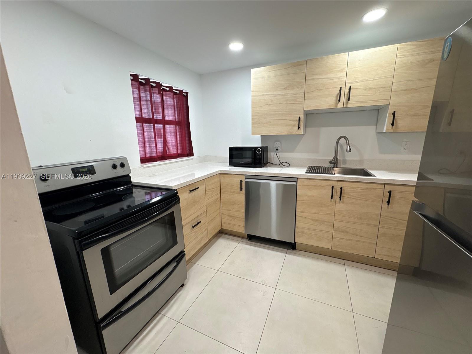 1331 Lincoln Road, Unit 402 Miami Beach, FL 33139 - Photo 8 of 20 a kitchen with a stove sink and cabinets