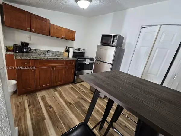 a kitchen with wooden cabinets and refrigerator