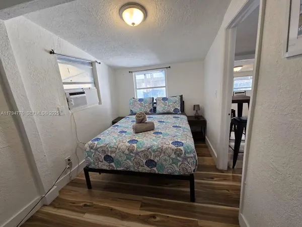 a bedroom with a bed and a mirror on the dresser