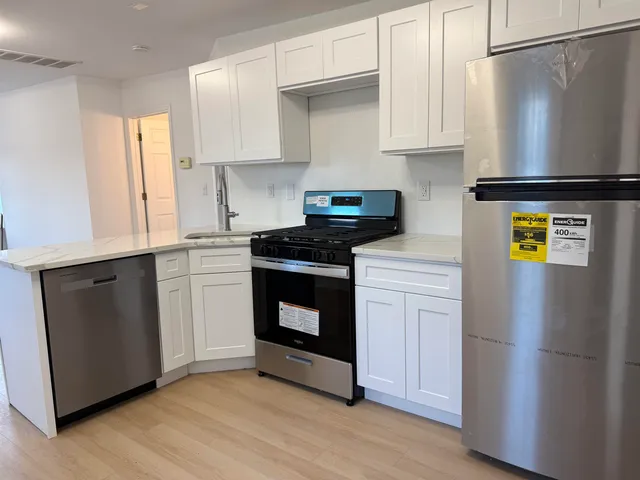 a kitchen with a refrigerator and a stove top oven