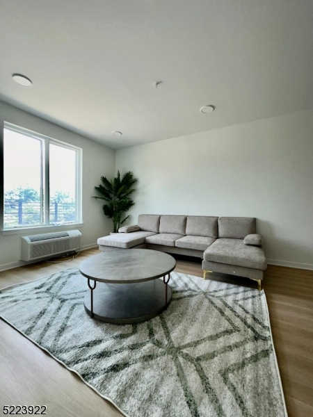 321 East 3rd Street, Unit 210 Plainfield, NJ 07060 - Photo 14 of 21 a living room with furniture and a large window