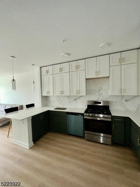 321 East 3rd Street, Unit 210 Plainfield, NJ 07060 - Photo 4 of 21 a kitchen with stainless steel appliances a stove a sink and a refrigerator