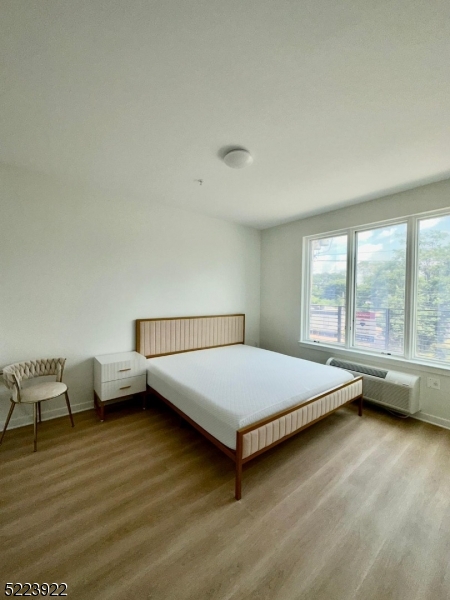 321 East 3rd Street, Unit 210 Plainfield, NJ 07060 - Photo 7 of 21 a bedroom with a bed and wooden floor