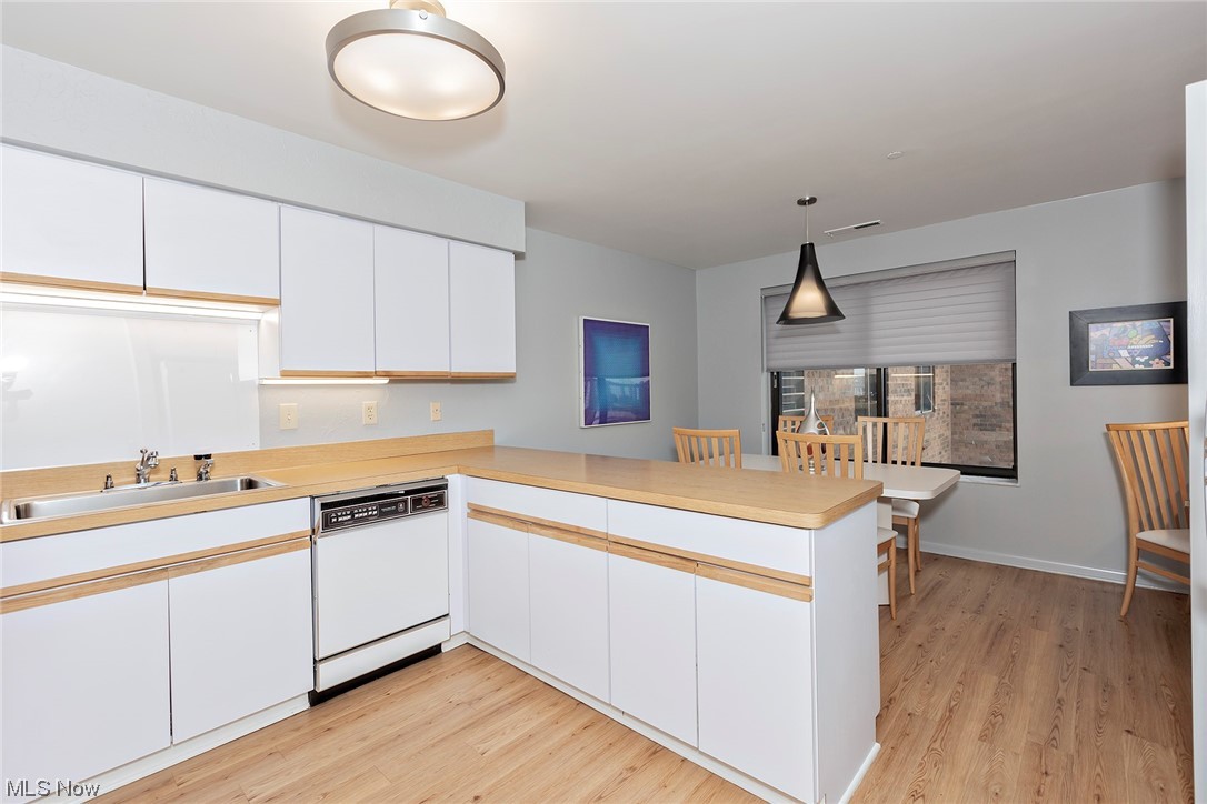 27500 Cedar Road, Unit 608 Beachwood, OH 44122 - Photo 11 of 34 Kitchen featuring decorative light fixtures, white cabinets, light countertops, light hardwood floors.