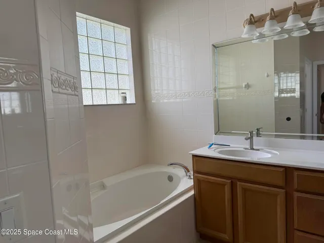 a bathroom with a tub sink and mirror