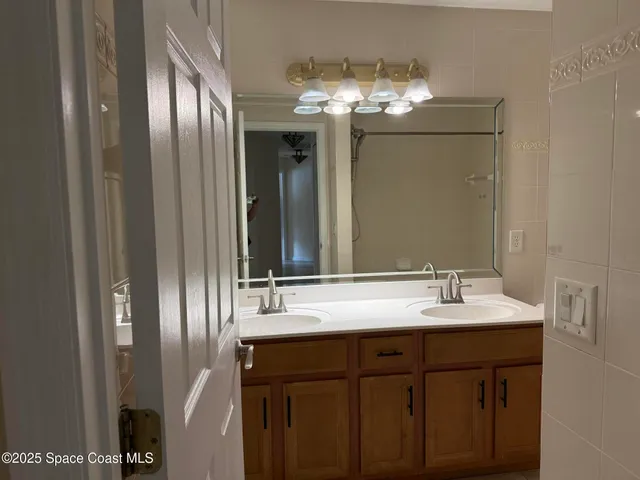 a bathroom with a double vanity sink and a mirror