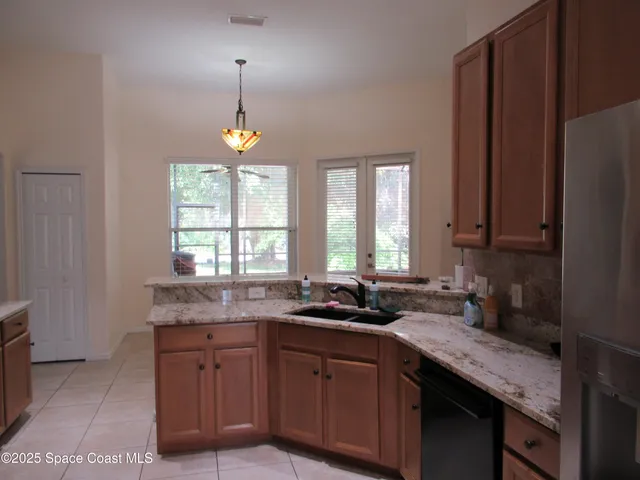a kitchen with granite countertop cabinets a sink a window and stainless steel appliances