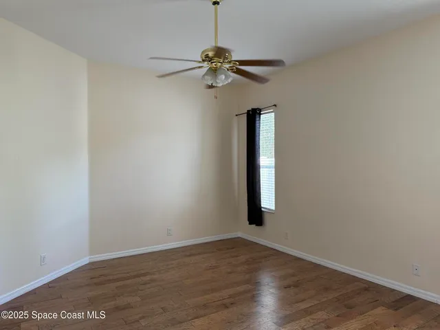 a view of a livingroom with a fan and a window
