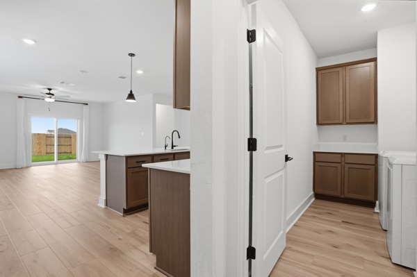 201 Prodigal Way Kyle, TX 78640 - Photo 11 of 22 The property features an open-concept living area with light wood-style flooring and recessed lighting