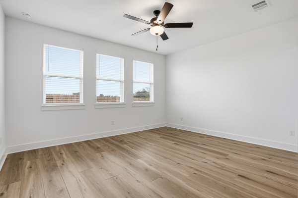 201 Prodigal Way Kyle, TX 78640 - Photo 13 of 22 Room featuring light-toned flooring, white walls, and three windows with blinds