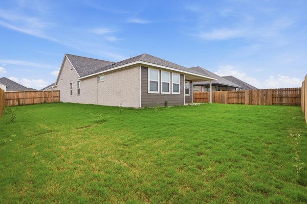 201 Prodigal Way Kyle, TX 78640 - Photo 22 of 22 The property features a spacious yard with a lush green lawn, enclosed by a wooden fence