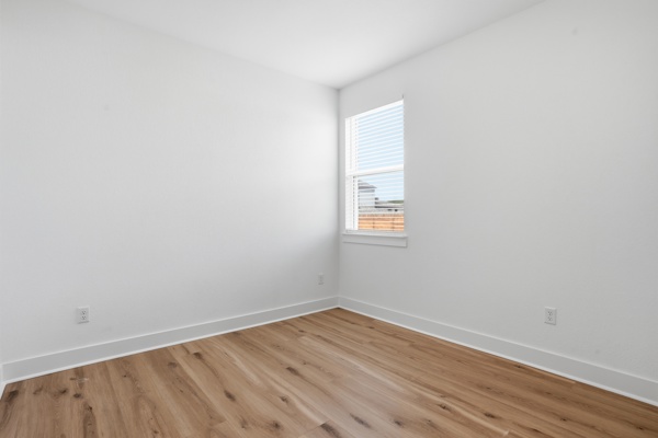 201 Prodigal Way Kyle, TX 78640 - Photo 9 of 22 Bright room featuring wood-style flooring and a window with horizontal blinds