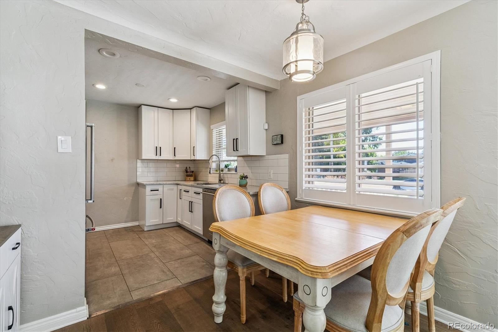 2660 Kearney Street Denver, CO 80207 - Photo 11 of 35 a kitchen with a table chairs sink stove and refrigerator