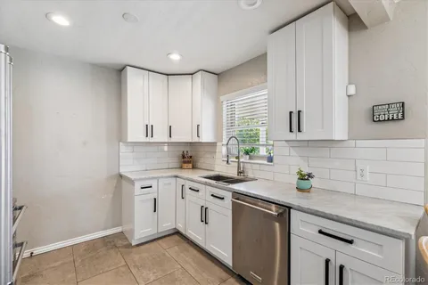 a kitchen with a sink dishwasher and white cabinets