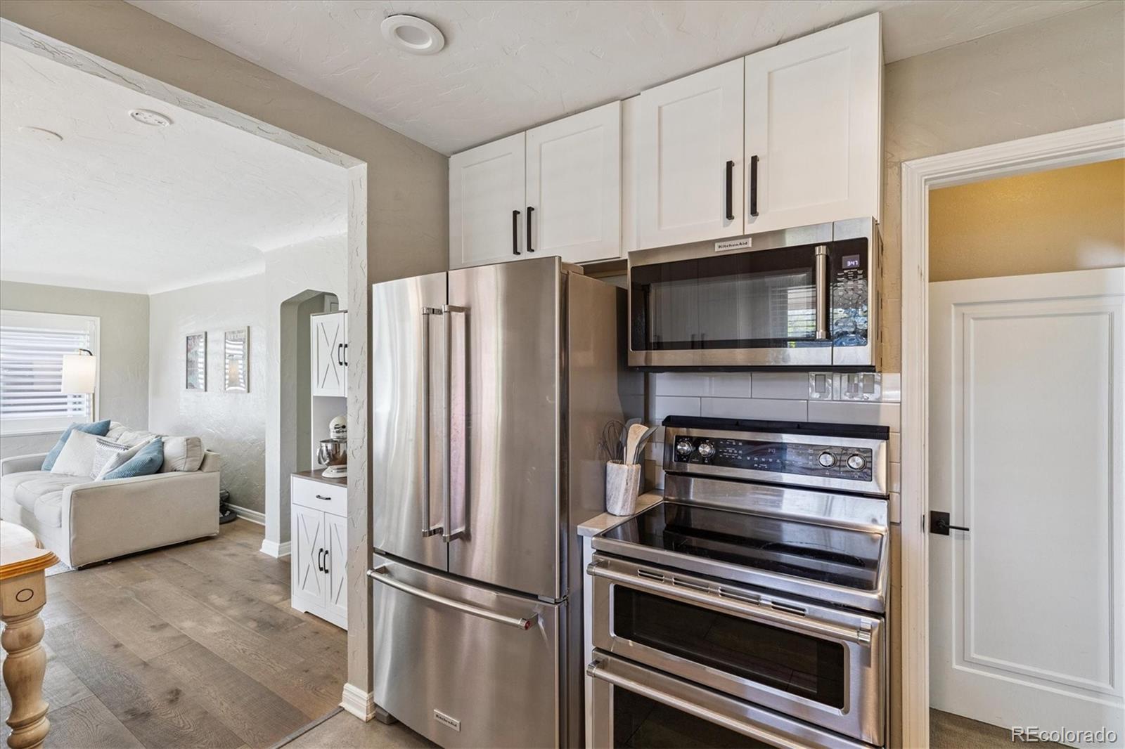 2660 Kearney Street Denver, CO 80207 - Photo 15 of 35 a kitchen with granite countertop a refrigerator and cabinets