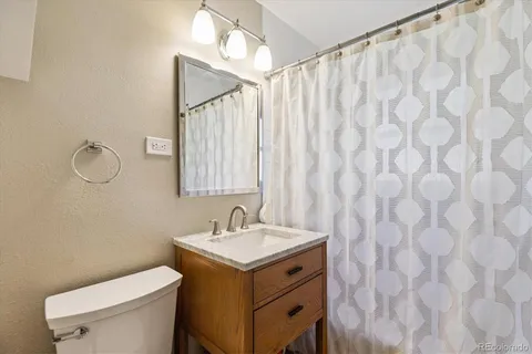a bathroom with a sink vanity mirror and toilet
