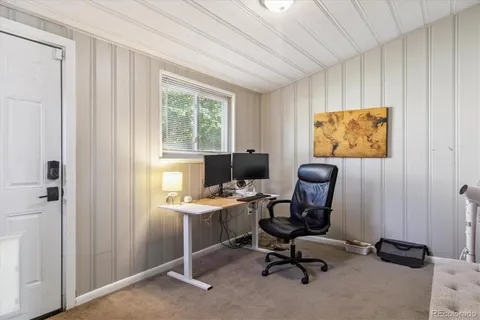 a view of a workspace with furniture and a window