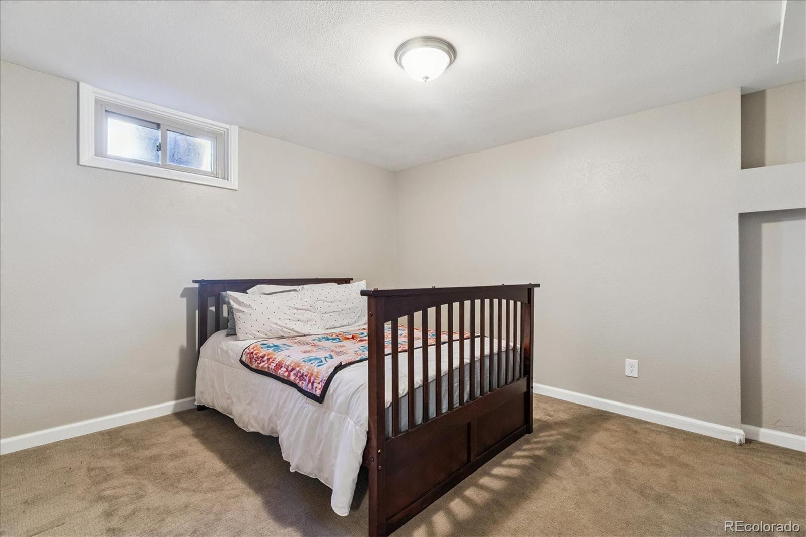 2660 Kearney Street Denver, CO 80207 - Photo 22 of 35 a bed sitting in a bedroom next to a window