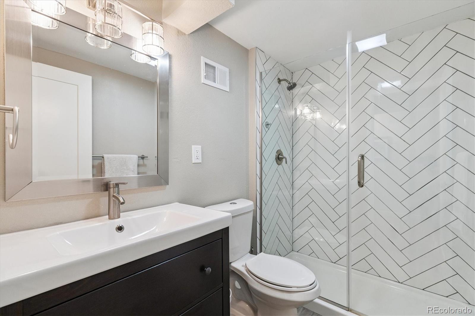 2660 Kearney Street Denver, CO 80207 - Photo 23 of 35 a bathroom with a sink a toilet and shower