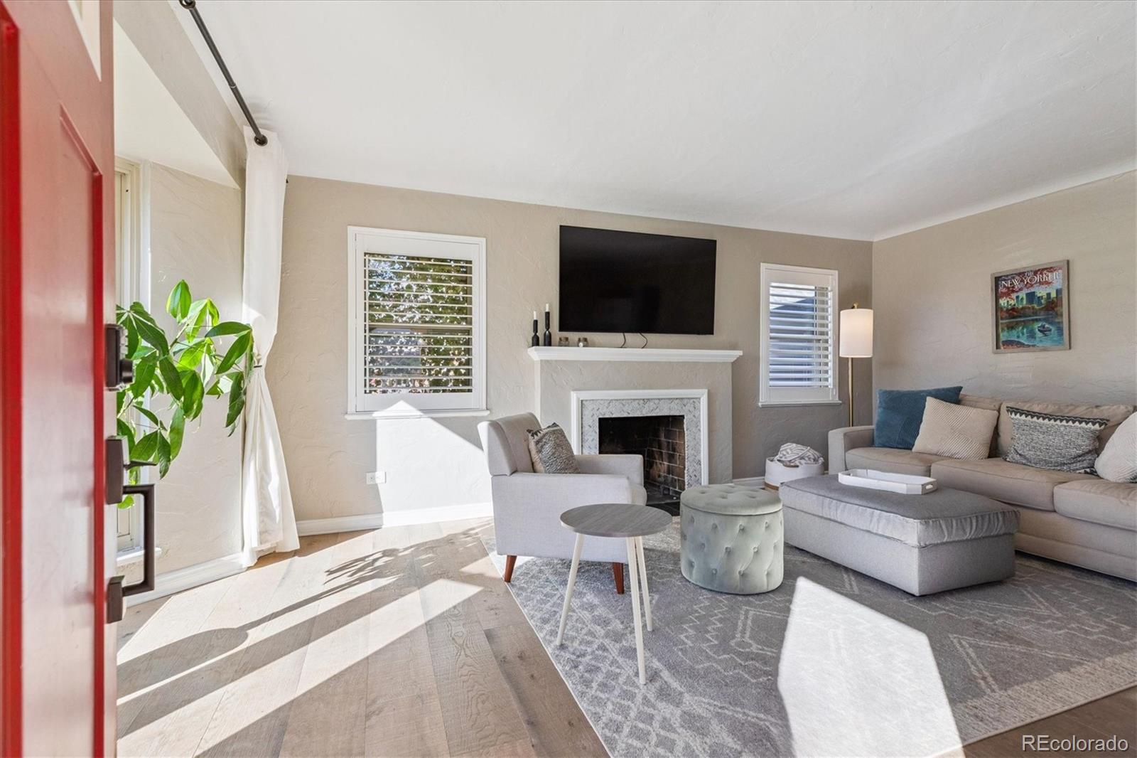 2660 Kearney Street Denver, CO 80207 - Photo 5 of 35 a living room with furniture a flat screen tv and a fireplace