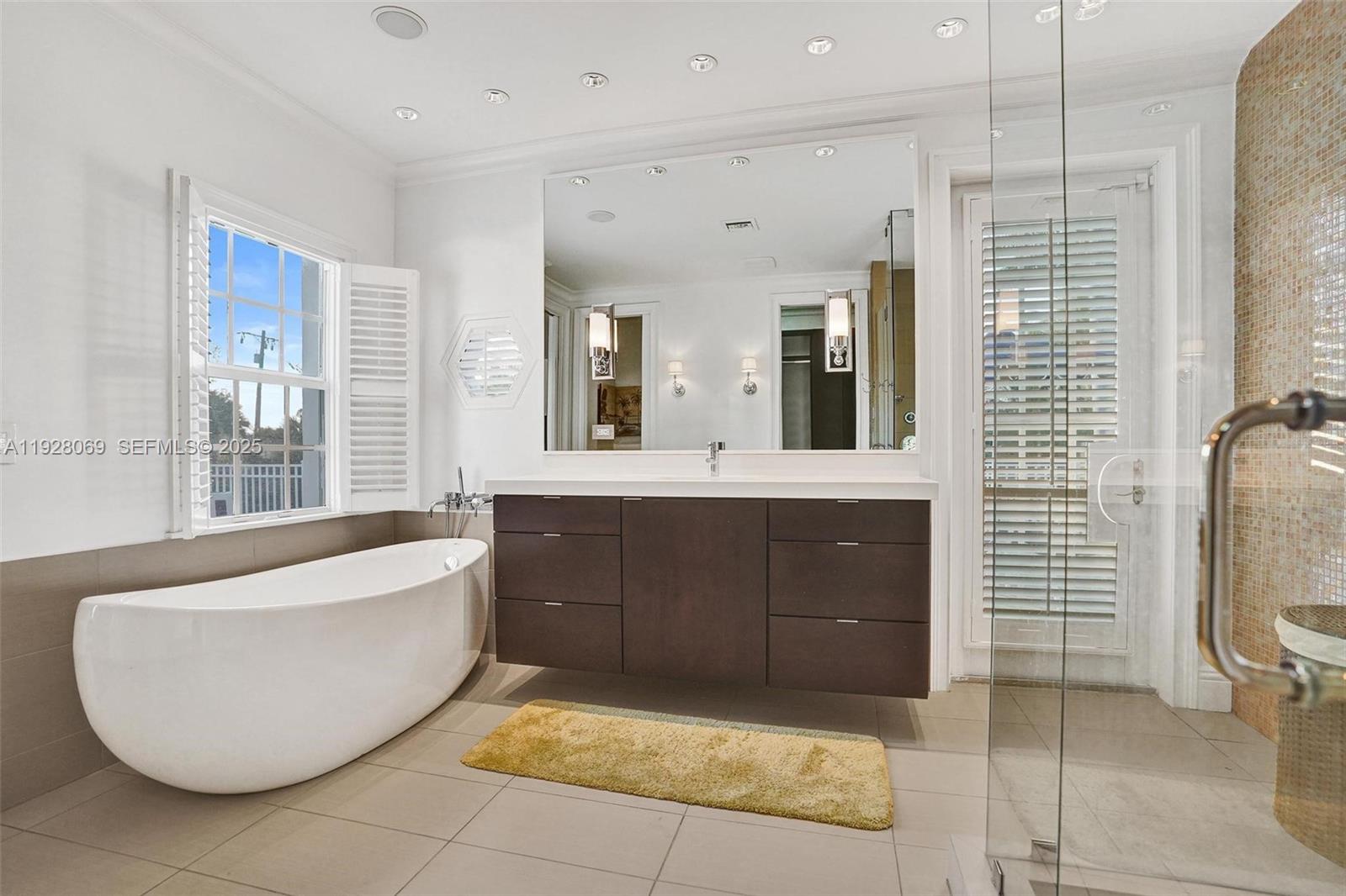 1281 Banyan Road Boca Raton, FL 33432 - Photo 57 of 69 a bathroom with a tub sink and mirror