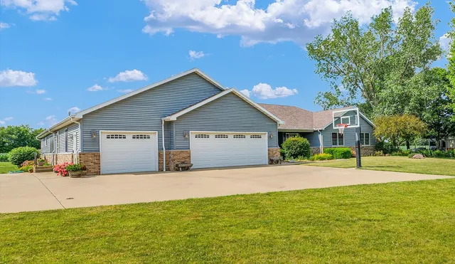 a view of house in front of a big yard with large trees