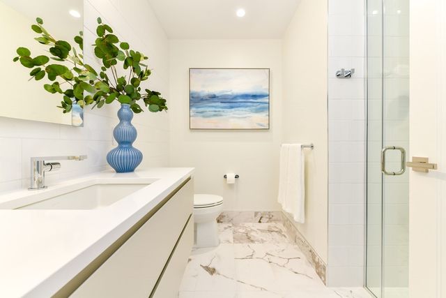 a bathroom with a sink a toilet and a mirror