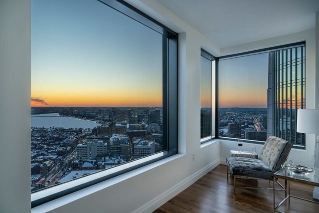a view of a room with a large window and wooden floor