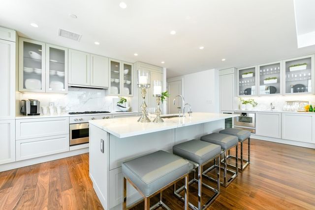 a kitchen with a dining table chairs and white cabinets