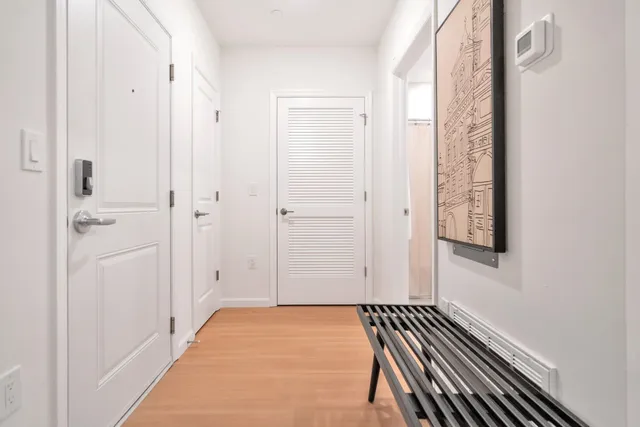 a view of a hallway with wooden floor and staircase
