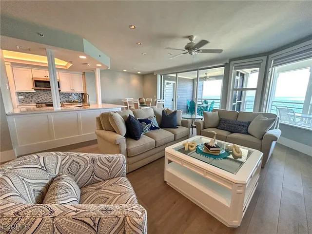 a living room with furniture kitchen and a large window