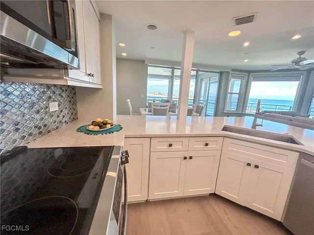 a kitchen with white cabinets and sink