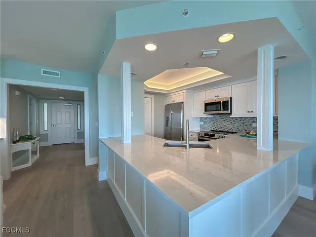 a large white kitchen with a large window