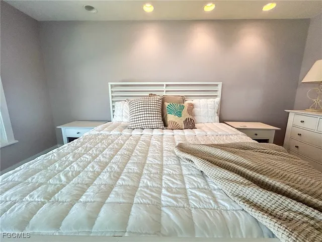 a bedroom with a large bed and a chandelier