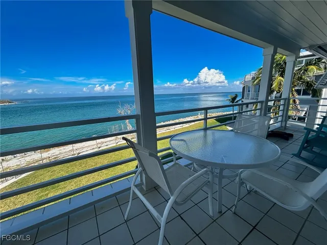 a view of a porch with chairs and floor to ceiling window