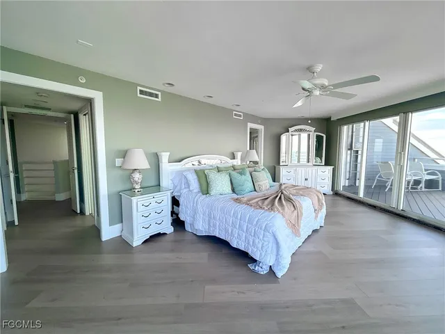a spacious bedroom with a balcony a bed and a large window