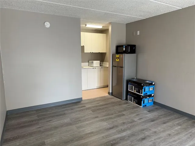 a kitchen with a refrigerator cabinets and wooden floor