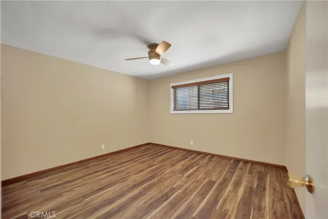 a view of a room with wooden floor and ceiling fan