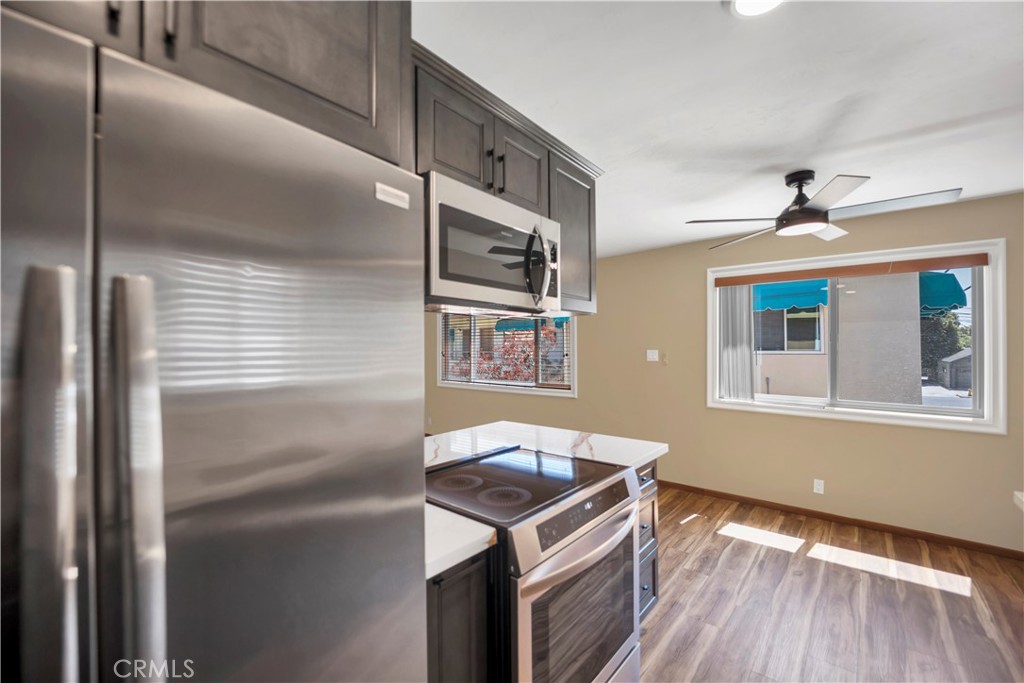 2214 2nd Street, Unit 6 Long Beach, CA 90803 - Photo 4 of 22 a kitchen with stainless steel appliances granite countertop a refrigerator a stove and a sink with wooden floor
