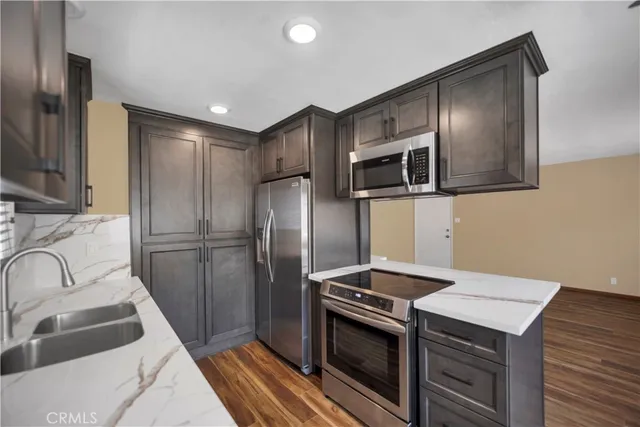 a kitchen with stainless steel appliances granite countertop a refrigerator and a sink