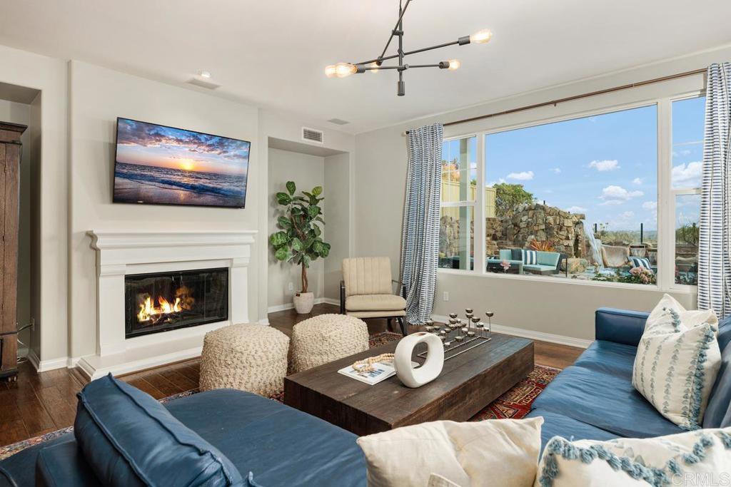 7627 Circulo Sequoia Carlsbad, CA 92009 - Photo 19 of 72 a living room with furniture a flat screen tv and a fireplace