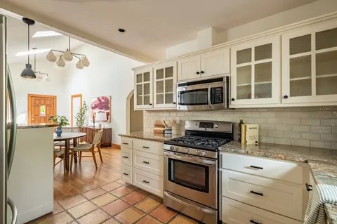 a kitchen with cabinets appliances and a dining table