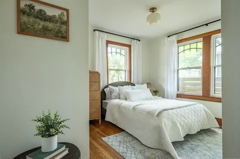 a bedroom with a bed and a potted plant