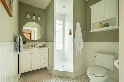 a bathroom with a toilet a sink and mirror
