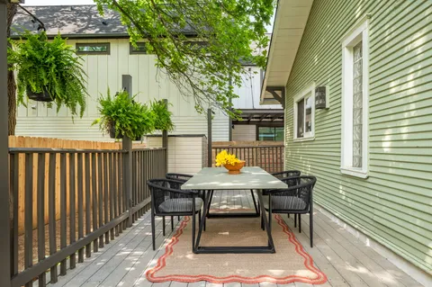 a view of a wooden bench sitting in back of a house