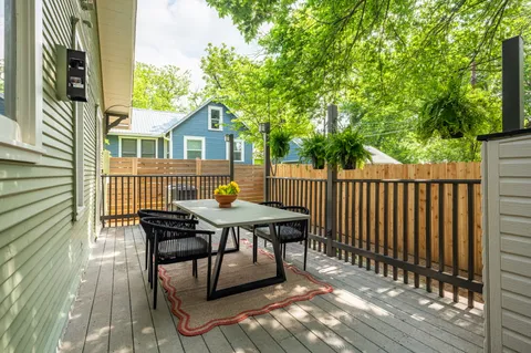 a view of a deck with table and chairs with wooden floor and fence