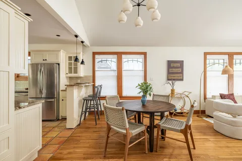 a dining room with furniture a chandelier and wooden floor